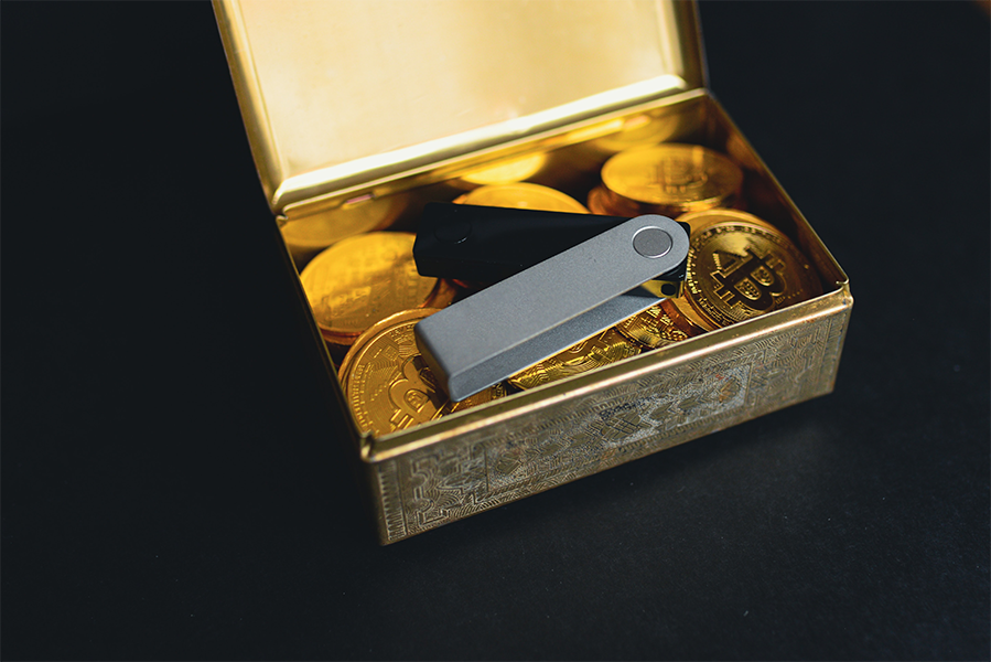 A vintage gold box containing gold bitcoins and a crypto key